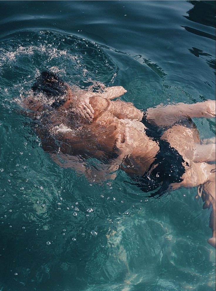 People swimming together in clear water.