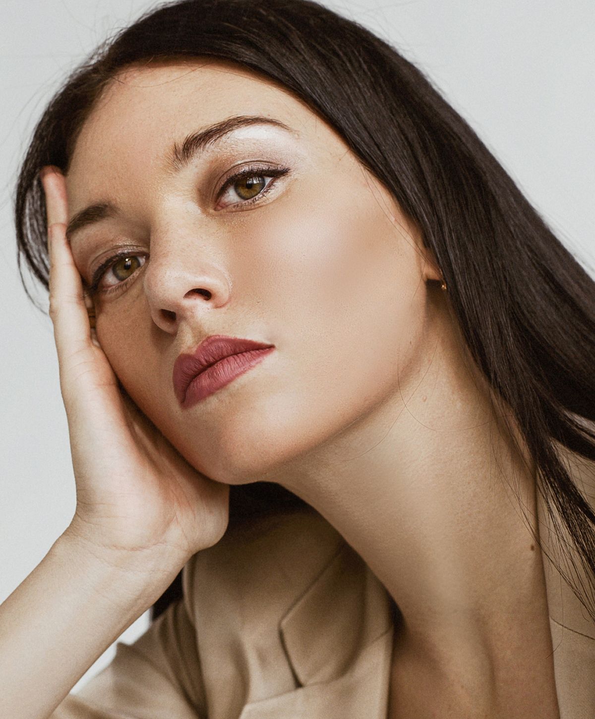 Woman resting her head on hand, thoughtful expression.
