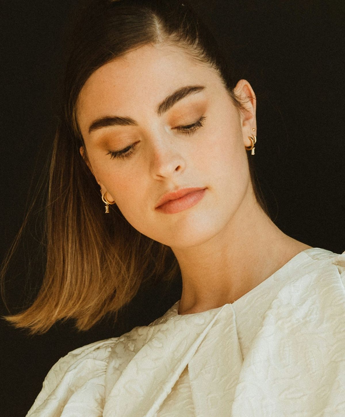 Woman with long, wavy hair and soft features.