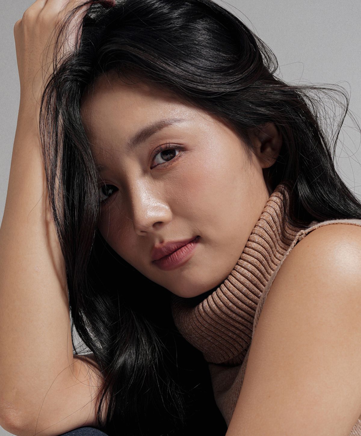 Young woman with long black hair and sweater.