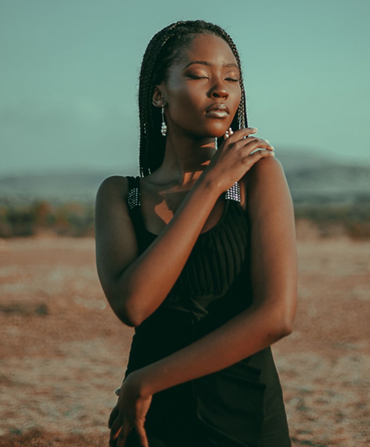 Woman in black dress basking in sunlight.