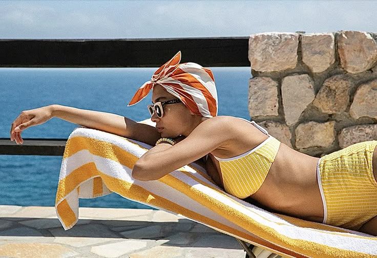 Woman sunbathing by the seaside in summer attire.