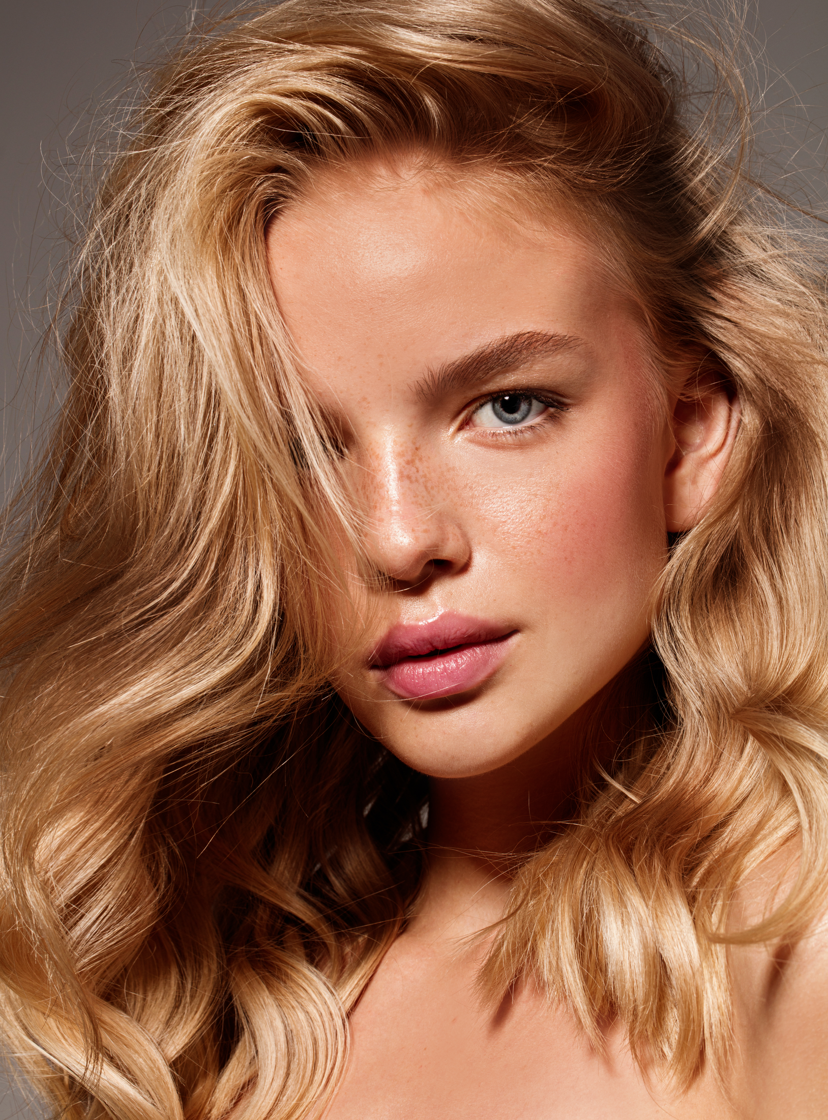 Close-up of a model with wavy blonde hair.