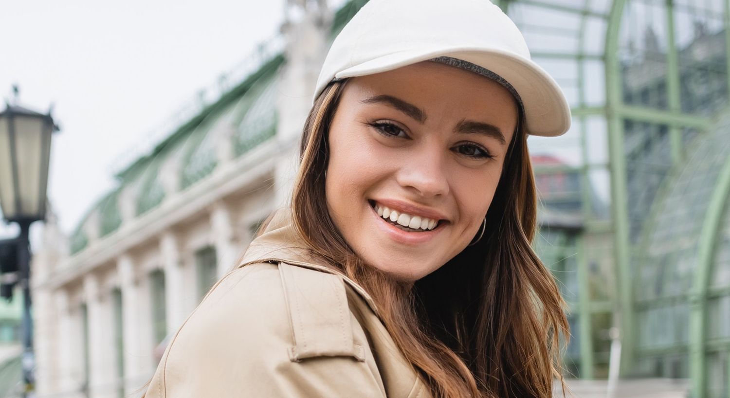 Smiling woman in a cap outdoors.