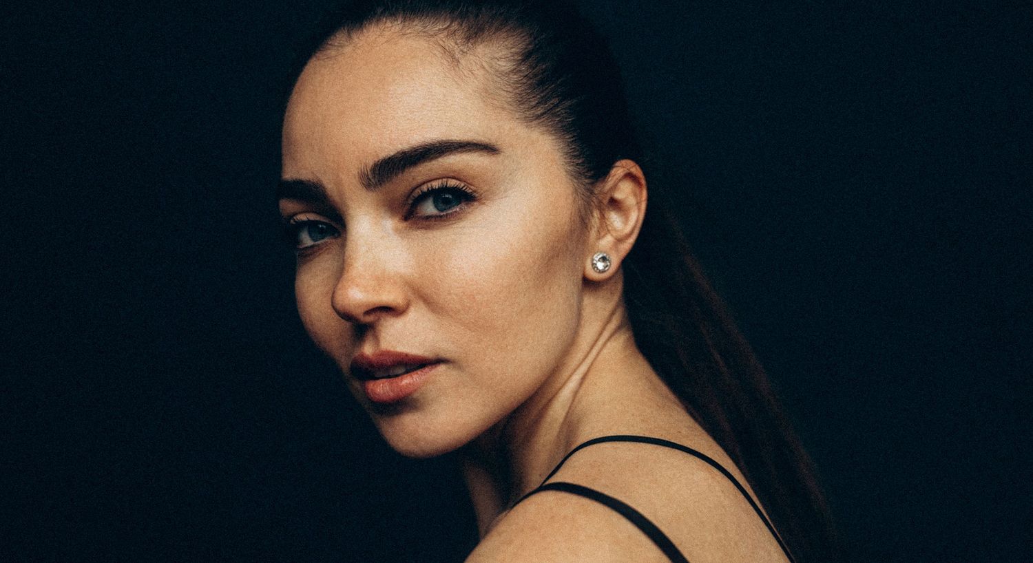 Portrait of a woman against a dark background.