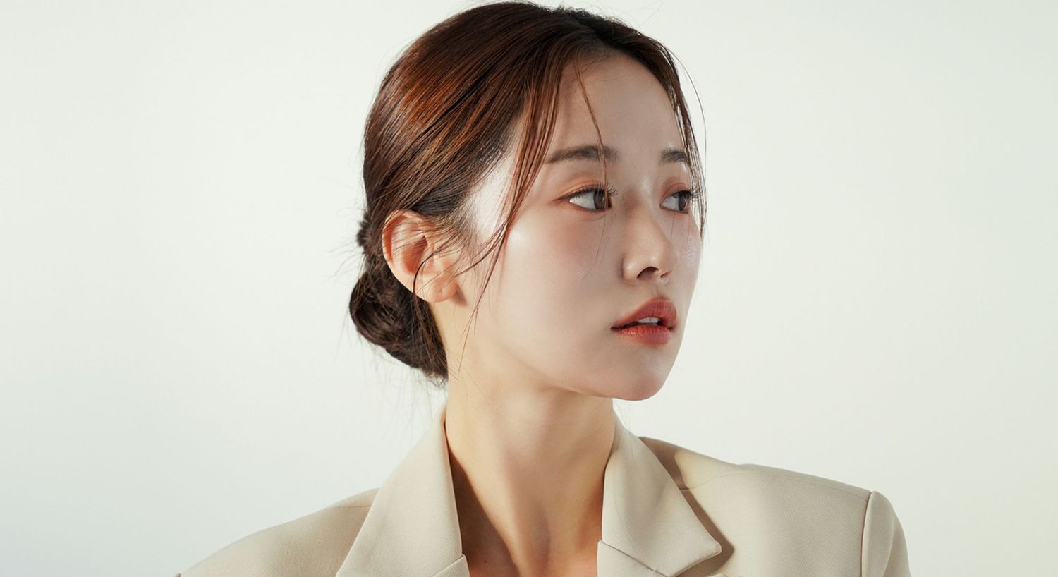 Profile of a woman in neutral-toned outfit.