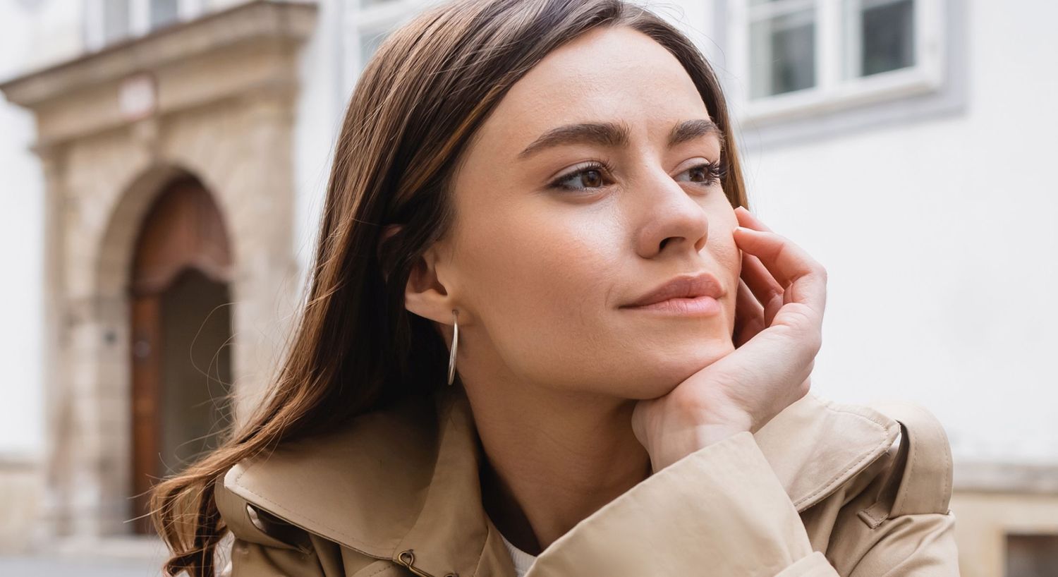 Thoughtful woman in a stylish coat outdoors.