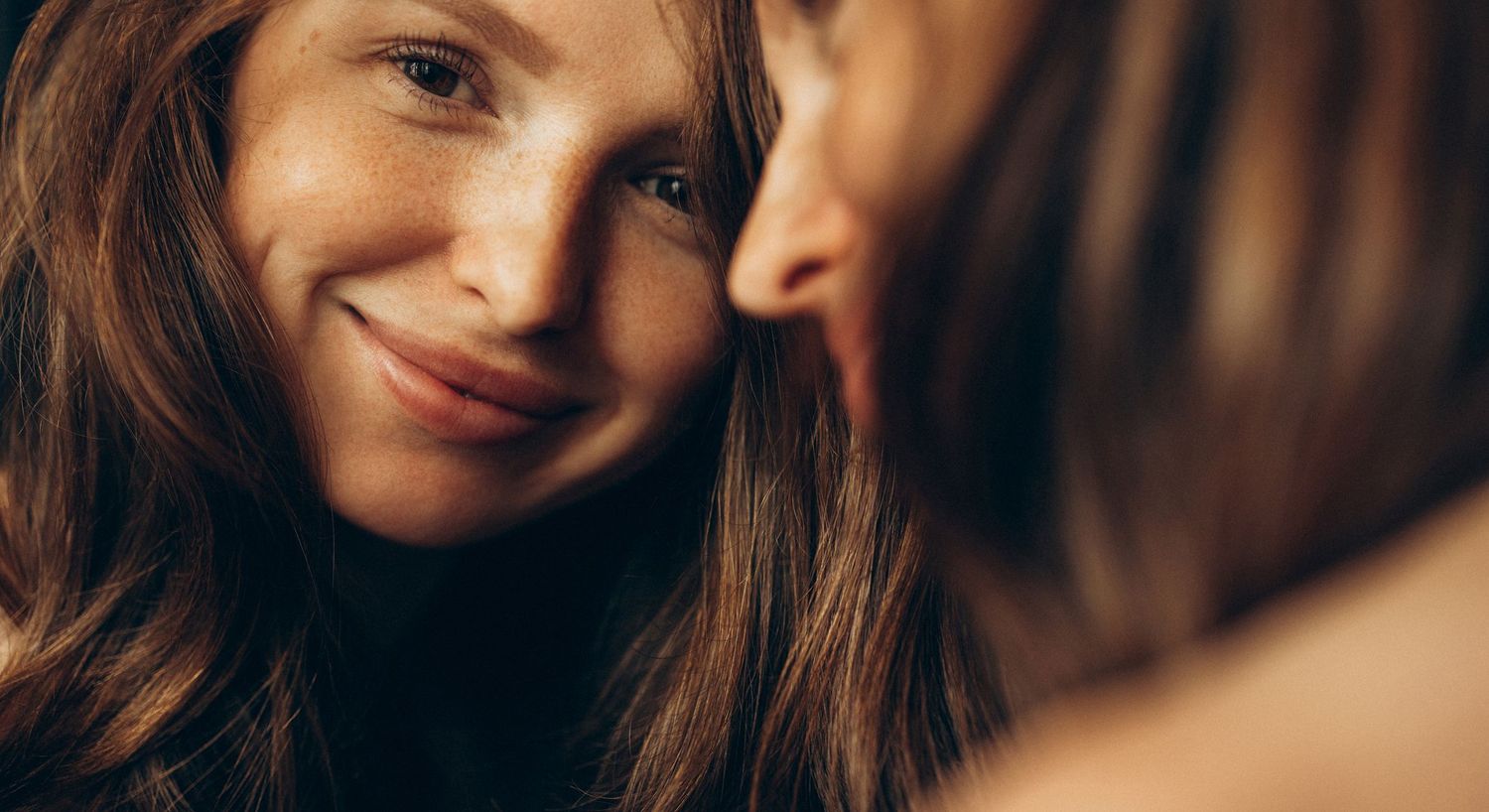 Smiling woman with long hair, close-up portrait.