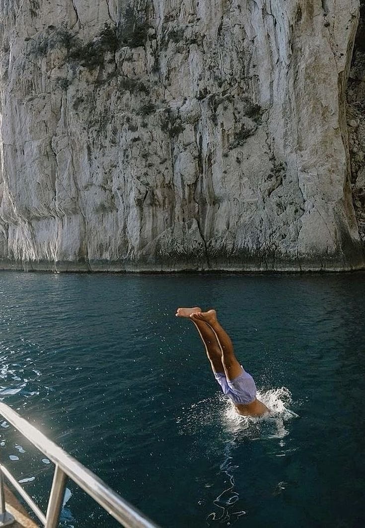 Person diving into clear blue water.